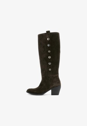 Brune ruskind knæhøje støvler med en let hæl og dekorative sølvknapper langs siden. Glat tekstur og tætsiddende form.