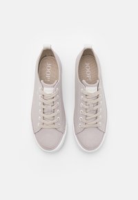 Ljusgrå canvas sneakers med vita gummisålar, rund tå, sex hälöppningar för snörning och en logotyp tryckt inuti skon.