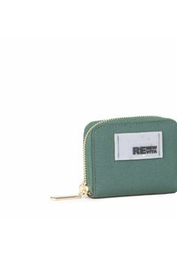 Cartera verde texturizada con cremallera dorada, que presenta un parche blanco con el logo "RENEW VITA". Forma rectangular compacta para facilitar su transporte.