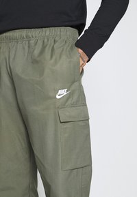 Gröna Nike cargo shorts med elastisk midja, sidoficka och broderad logotyp; lättviktigt tyg med en mjuk textur.