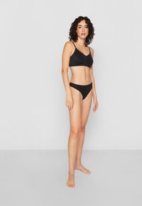 Black bikini set consisting of a bralette and high-waisted bottoms, featuring thin straps and a smooth, stretchy texture.