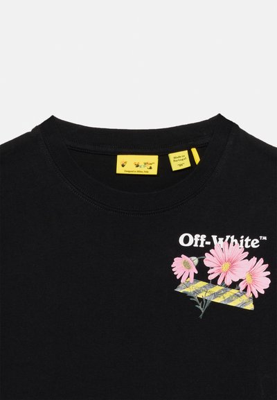 Μαύρο T-shirt Off-White με ροζ λουλούδια μαργαρίτας και κίτρινες διαγώνιες ρίγες τυπωμένες κοντά στον λαιμό, καθώς και κίτρινες ετικέτες μάρκας μέσα στον γιακά.