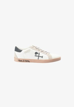 Zapatilla blanca con detalles en gris, con un talón de ante, cordones en la parte delantera y un gráfico decorativo en el lateral. Suela de goma marrón.