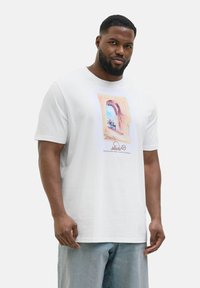 Hvid bomulds T-shirt med et farverigt, illustreret vinduesdesign med blomster. Korte ærmer og en afslappet pasform.