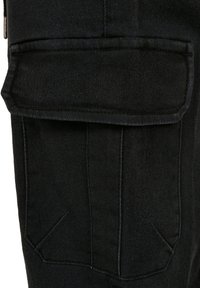 Black denim pants featuring a large, flat cargo pocket, visible stitching, and a smooth texture. The design includes angled side seams.