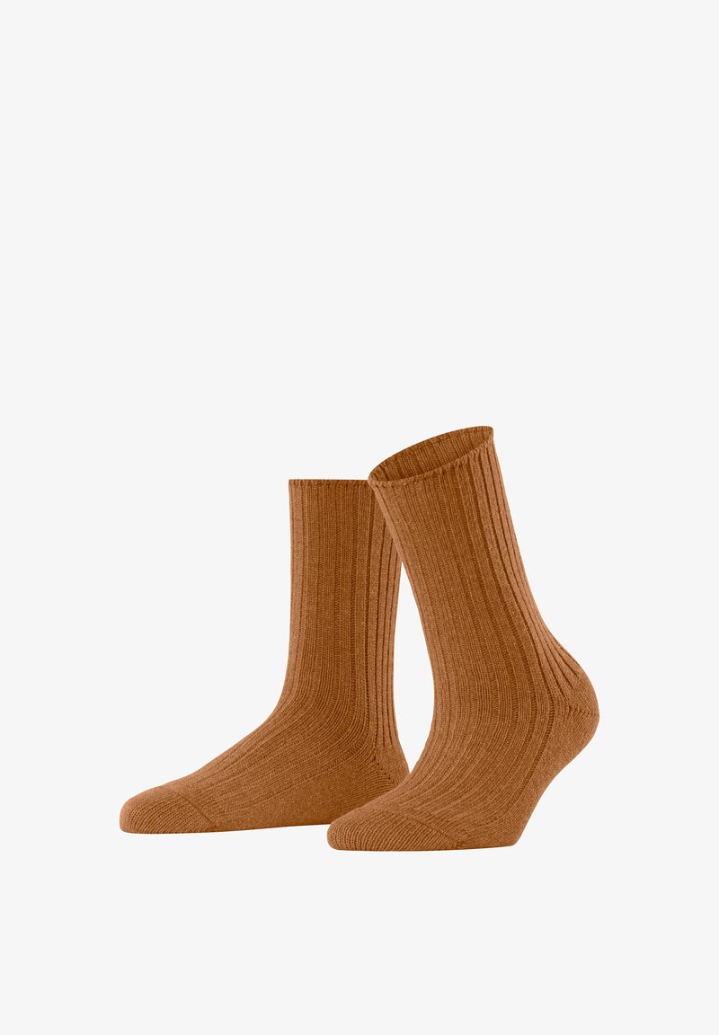 Rippstrumpfen in einem warmen Braunton, aus einem weichen Stoff gefertigt. Das Design hat eine Höhe bis zur Mitte der Wade mit verstärkten Zehen- und Fersenbereichen.