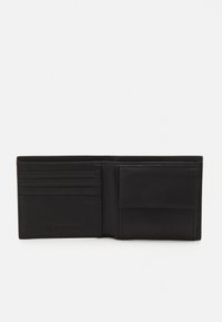 Portafoglio in pelle nera con sei slot per carte, una tasca aperta e un logo in rilievo discreto. Texture liscia e design semplice e pratico.