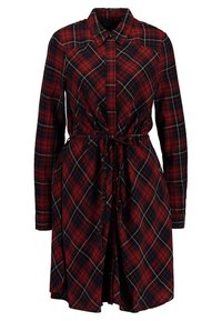 Punainen ruudullinen mekko pitkillä hihoilla, kauluksella, napit edessä, kiristetty vyötärö vyöllä ja leveä A-linjainen hame.