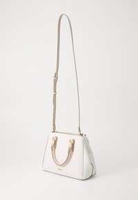 Sac à main blanc et crème avec un design structuré, quincaillerie dorée, poignées supérieures doubles et une bandoulière réglable. Texture lisse, accents minimaux.
