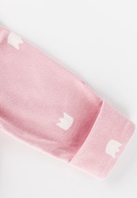 Rosa Baumwollsocke mit einem weißen Kronenmuster. Weiche Textur, gerippter Bund und glatte Oberfläche mit leichtem Glanz.