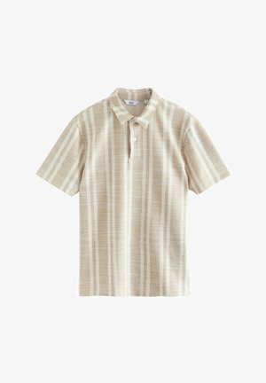 Īsām piedurknēm polo krekls bēšā krāsā ar baltām vertikālām svītrām. Izgatavots no teksturēta auduma, ar klasisku apkakli un pogu aizdari.