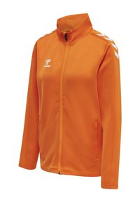 Oranje sportjack met volledige rits, witte chevronstrepen op de schouders en wit hummel-logo op de borst, met zijzakken en lange mouwen.