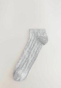 Grå stickad strumpa med ribbat mönster och kabelmönster, med förstärkt häl och tå. Mjuk, lätt material.
