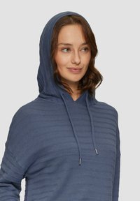 Hoodie in diepblauw met een gestructureerd gestreept ontwerp. Beschikt over een voorzak en verstelbare koorden voor de kap.