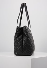Bolso tote de cuero negro acolchado con dos asas, que presenta una forma espaciosa y estructurada, y una textura suave.