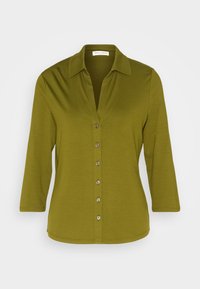 Olivengrøn bluse med spids krave, trekvartærmer og knaplukning foran med sølvknapper. Blødt, glat stof.