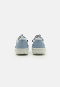 Zapatillas deportivas de color azul claro con parte superior de malla texturizada, suela de goma blanca y acento negro en el talón.