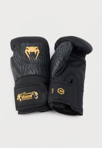 Μαύρα γάντια πυγμαχίας με υφή, χρυσό λογότυπο φιδιού και λουράκι με βέλκρο. Μέγεθος 10 ουγκιές εμφανίζεται στο πλάι. Ανθεκτικό υλικό.