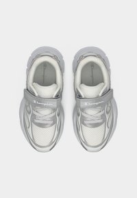 Λευκά και γκρι αθλητικά παπούτσια με ύφασμα δίχτυ, επενδεδυμένους γιακάδες και ρυθμιζόμενους ιμάντες. Διαθέτουν εμφανές λογότυπο Champion στον ιμάντα και στις σόλες.