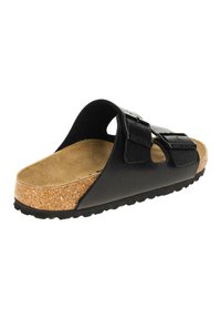 Sandales noires avec deux bretelles réglables, matériau supérieur texturé et semelle en liège. Semelle en caoutchouc avec un motif de profil défini.