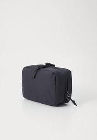 Compact black travel pouch made of durable fabric with a rectangular shape, smooth texture, zipper closure, and a top strap handle.