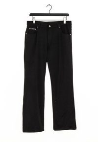 Svarta jeans hängande på en svart galge, med en rak ben design, två framfickor och metallaccessoarer.