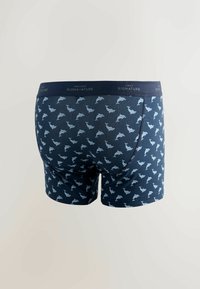 Granatowe bokserki w wzór z delfinami, wykonane z teksturowanej tkaniny, z ciemnym pasem z napisem "SIGNATURE".