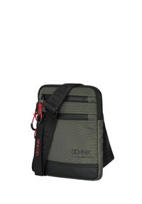 Zielona i czarna torba na ramię z dwoma zamykanymi na zamek kieszeniami z przodu, regulowanym paskiem i czerwonymi akcentami. Wykonana z trwałego materiału nylonowego.