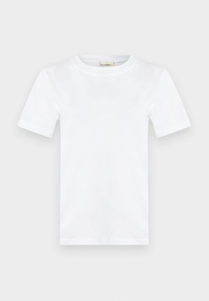 Απλό λευκό κοντομάνικο T-shirt με στρογγυλή λαιμόκοψη και μια μικρή μπεζ ετικέτα μέσα στο γιακά που γράφει "CLOSED."