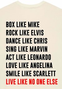 T-shirt couleur crème avec du texte noir en gras comprenant des noms et des actions, souligné par une phrase rouge en bas. Design simple axé sur le texte.