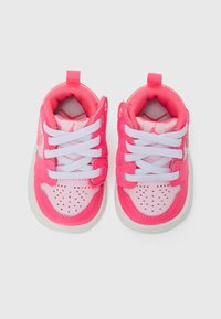 Pink athletic shoes with white laces, featuring a padded tongue and perforated toe, textured upper, and a logo detail on the side.