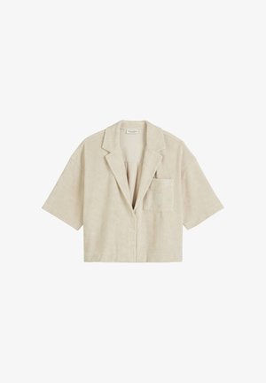 Beige cropped shirtjacket van zachte suédecategorie stof. Kenmerkt zich door een geknipte kraag, korte mouwen, knopen aan de voorkant en een borstzak.