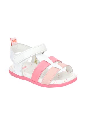 Biała i różowa sandałka dla malucha z paskiem na rzep, otwartym noskiem, miękką podeszwą i metką marki na pasku przy pięcie.