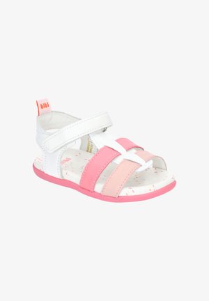 Biała i różowa sandałka dla malucha z paskiem na rzep, otwartym noskiem, miękką podeszwą i metką marki na pasku przy pięcie.