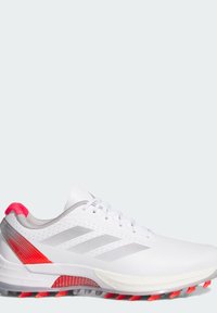 Witte sportschoen met grijze accenten, voorzien van een gestructureerde bovenkant, mesh panelen en helderrode details op de hiel en de loopzool.