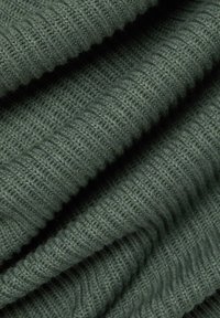 Getextureerde groene gebreide stof met geribd patroon, die een zachte weving, flexibele vorm en een gezellige uitstraling laat zien.