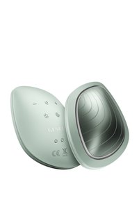 Dispositif ovale vert avec une finition mate lisse. Contient un miroir et des boutons pour le fonctionnement. Présente une texture ondulée sur la surface intérieure.