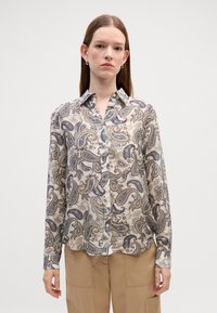 Camisa de botões feita de um tecido leve, apresentando um padrão paisley em tons de azul, creme e dourado, com colarinho clássico e mangas longas.