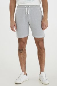 Gray cotton blend shorts with elastic waistband and drawstring. Features side pockets and a textured finish. Worn with white athletic shoes.