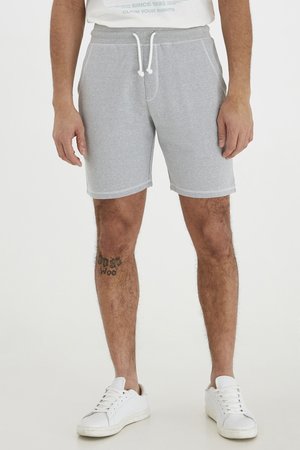 Gray cotton blend shorts with elastic waistband and drawstring. Features side pockets and a textured finish. Worn with white athletic shoes.