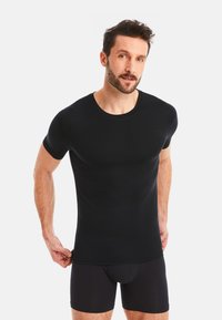 Black short-sleeve t-shirt made of smooth fabric, featuring a round neckline and snug fit, paired with black boxer shorts.
