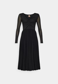 Robe noire avec de longues manches transparentes, un corsage ajusté avec des détails froncés et une jupe fluide et plissée. Texture de tissu lisse.