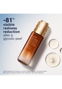 Bottiglia di vetro marrone con un tappo a vite dorato, etichettata "Advanced Night Repair", accompagnata da gocce di gel trasparente su uno sfondo chiaro.