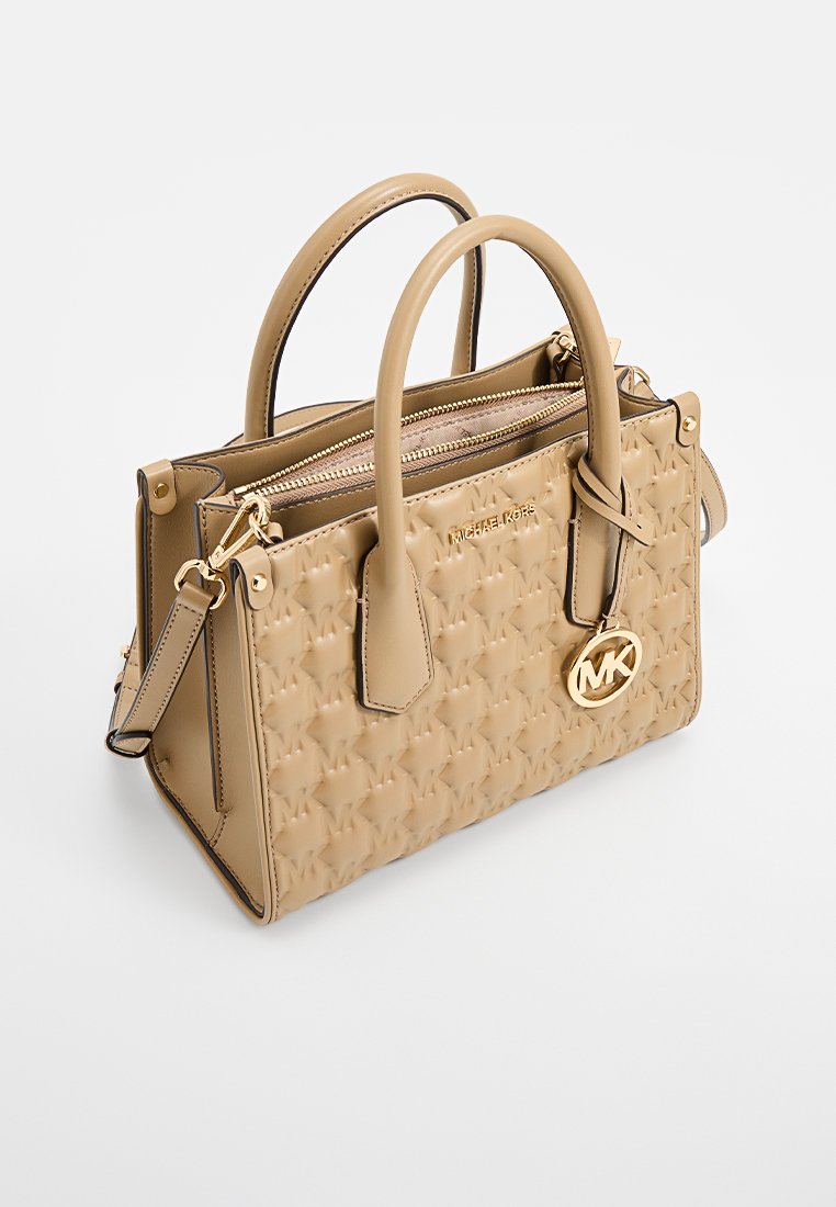 Sac à main en cuir beige avec motif logo gaufré, double poignées supérieures et bandoulière détachable. Éléments en métal doré.