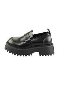 Sorte lærloafers med en tykk, teksturert svart gummisåle. Har en rund tå og en dekorativ stropp over vampen.