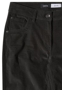 Gros plan d’un pantalon noir avec poches avant, fermeture par boutons, passants pour ceinture et une étiquette indiquant "Cecil Pants" à la taille.
