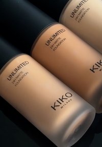 Drei KIKO Milano 24h Matte Foundation-Flaschen in unterschiedlichen Hauttönen, aus opakem Kunststoff mit schwarzen Kappen, mattem Finish und klaren Etiketten.