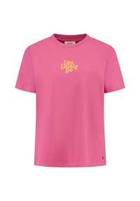 Vaaleanpunainen puuvillapaita, jossa on lyhyet hihat ja pyöreä kaula-aukko. Edessä on keltainen teksti "Like Locals Do" ja pieni logotieto helmassa.