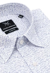 Biała koszula slim-fit z niebieskim graficznym wzorem zwierząt. Posiada kołnierzyk zapinany na guziki oraz gładkie białe guziki. Widoczna etykieta wewnątrz.