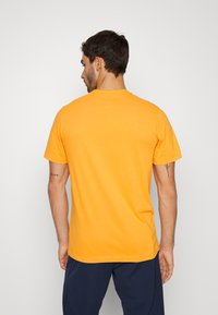 Nike Performance CREW SOLID - T-shirt desportiva - kumquat/black
